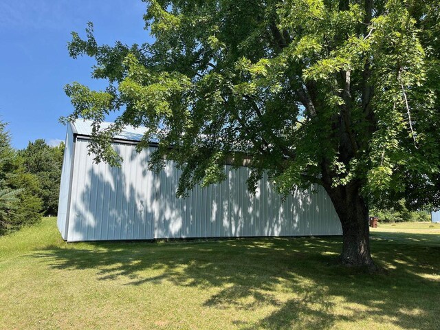 view of side of home with an outbuilding and a yard