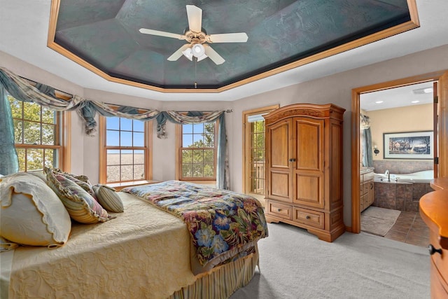 bedroom featuring ensuite bathroom, carpet, ceiling fan, and a tray ceiling