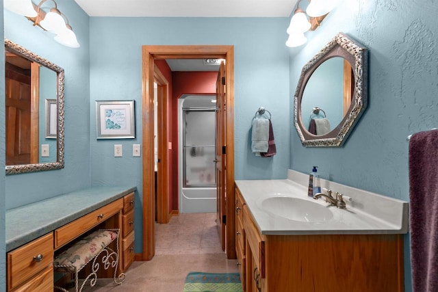 bathroom featuring bath / shower combo with glass door and vanity