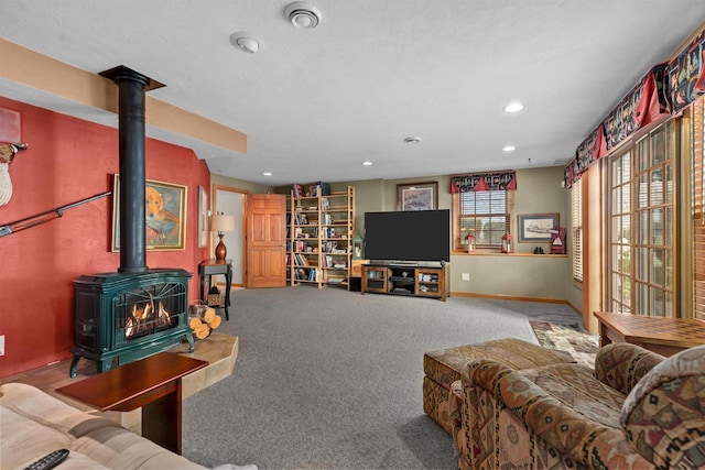 living room with carpet floors and a wood stove