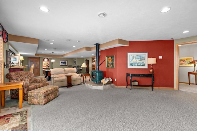 living room featuring carpet flooring and a wood stove