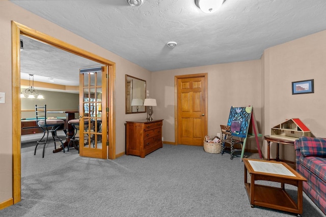 sitting room with a textured ceiling and carpet flooring