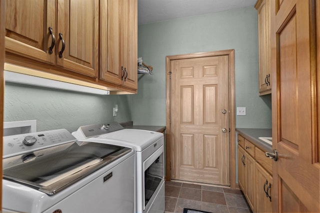 clothes washing area with cabinets and washing machine and clothes dryer