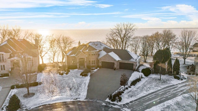 snowy aerial view featuring a water view