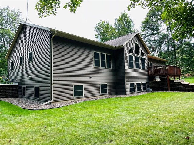 rear view of house with a deck and a yard