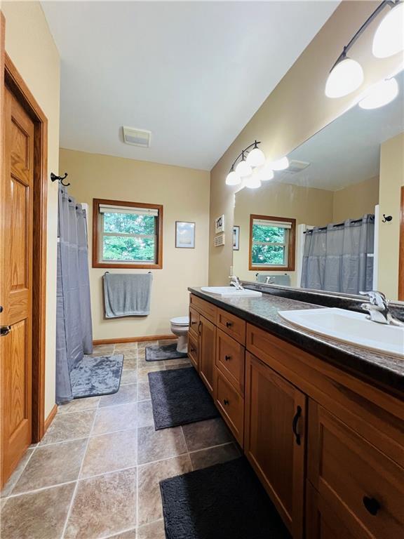 bathroom with vanity, a shower with shower curtain, tile patterned floors, and toilet