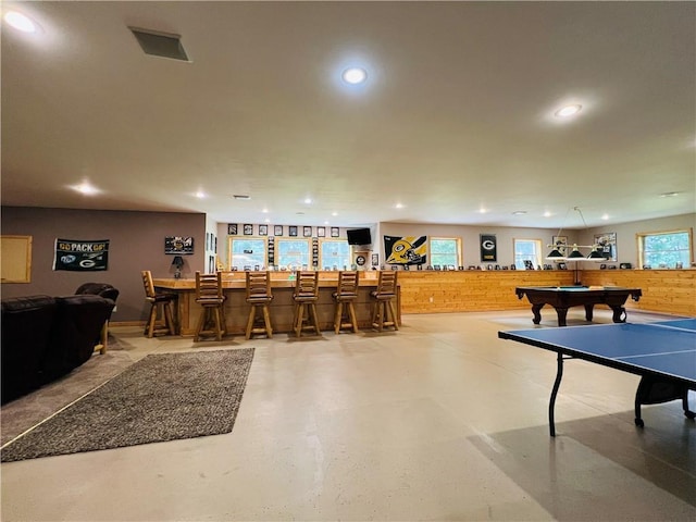 playroom with bar, pool table, and wood walls