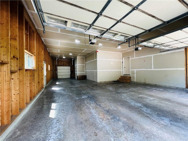 garage featuring a garage door opener and wooden walls