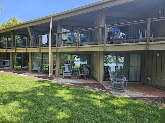 back of house with a patio area and a lawn