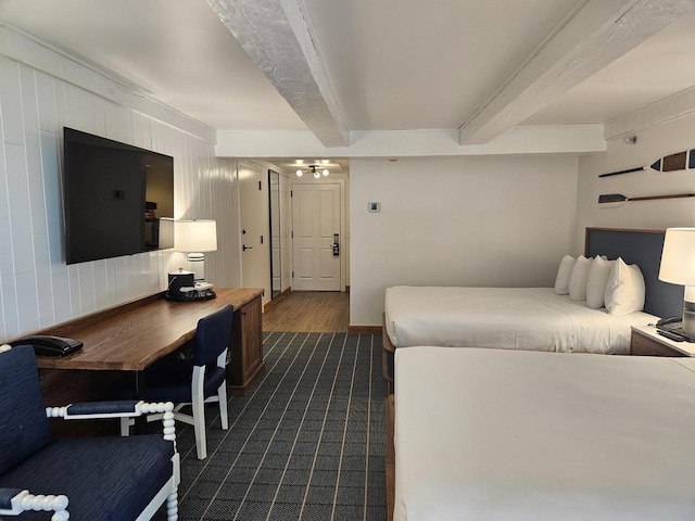 carpeted bedroom with beam ceiling