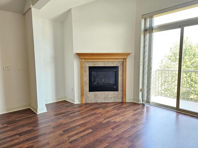 living room featuring a tile fireplace, a wealth of natural light, and hardwood / wood-style flooring