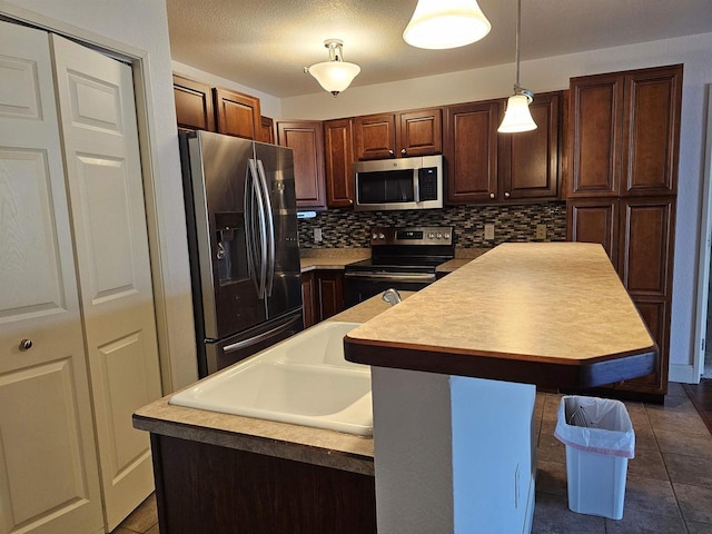 kitchen featuring backsplash, light tile patterned floors, stainless steel appliances, sink, and a center island with sink