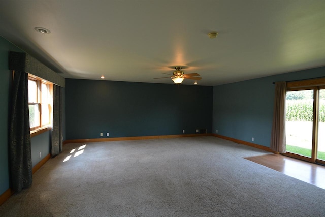 spare room with ceiling fan, carpet, and baseboards