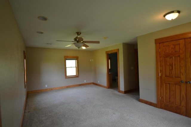 spare room with ceiling fan, baseboards, and light carpet