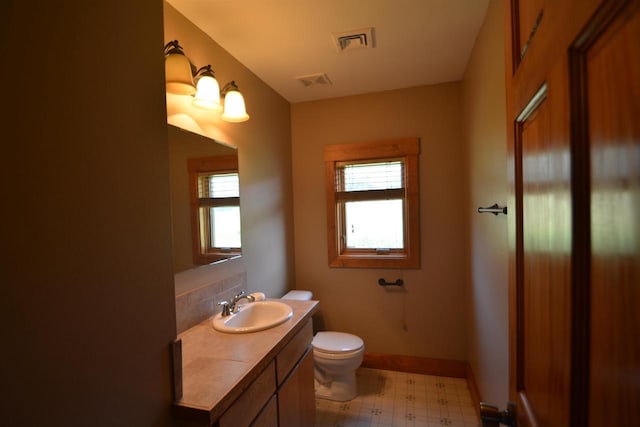 bathroom with a wealth of natural light, visible vents, toilet, and tile patterned floors