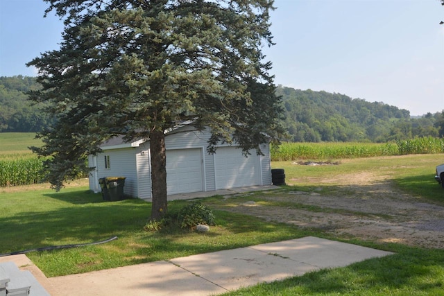 detached garage with a rural view and a view of trees