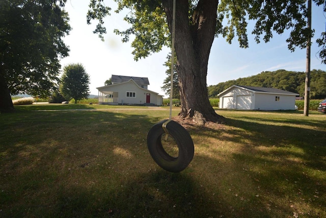 view of yard featuring a detached garage and an outbuilding