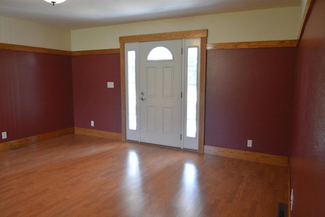 foyer entrance featuring baseboards, light wood-type flooring, and a wealth of natural light