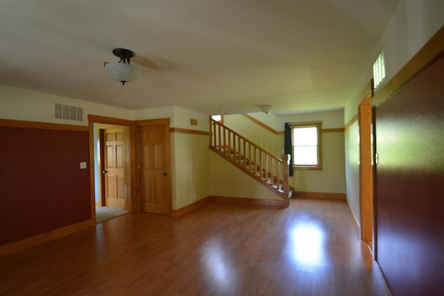 interior space featuring stairs, wood finished floors, visible vents, and baseboards