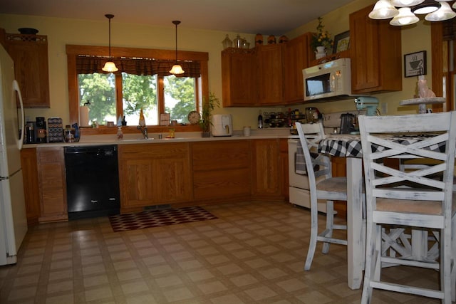 kitchen with a sink, white appliances, light floors, and light countertops