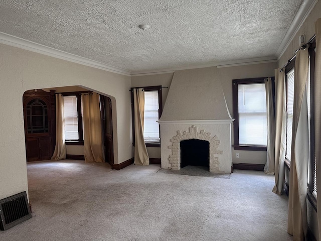 unfurnished living room featuring a wealth of natural light, light colored carpet, ornamental molding, and a fireplace