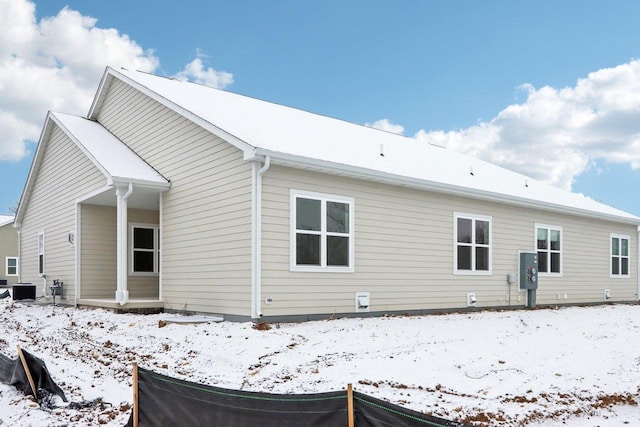 snow covered house with central air condition unit