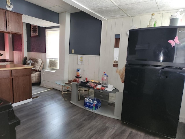 kitchen featuring cooling unit, a paneled ceiling, dark hardwood / wood-style flooring, and black appliances