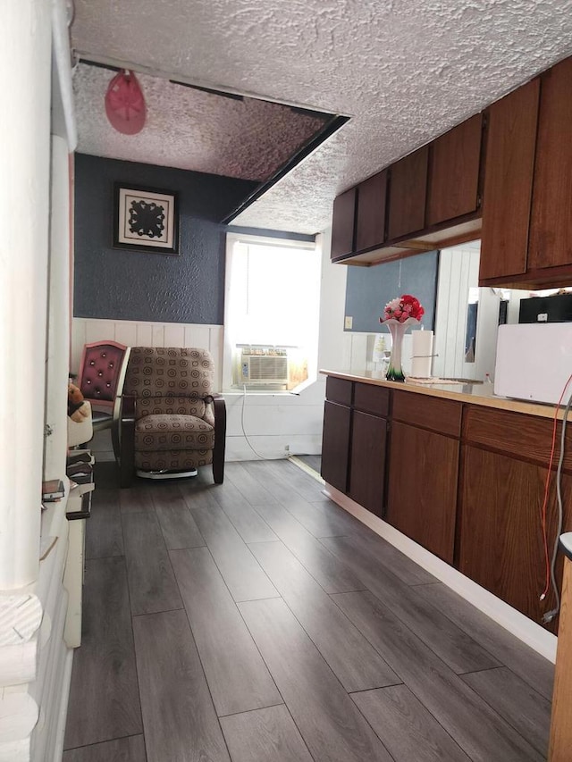 kitchen with dark hardwood / wood-style floors, cooling unit, and a textured ceiling