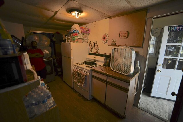 kitchen with hardwood / wood-style flooring, white appliances, and a paneled ceiling