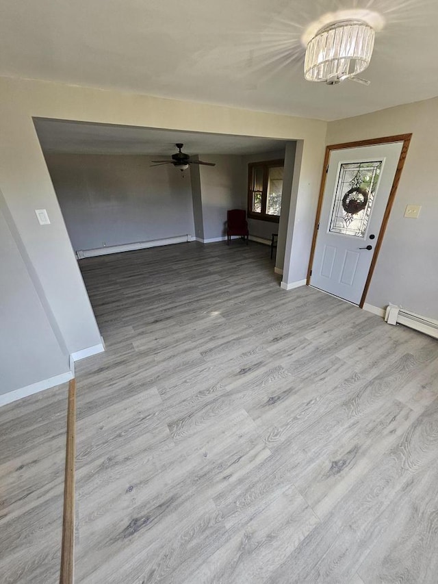 entryway with light wood-type flooring, baseboard heating, and ceiling fan