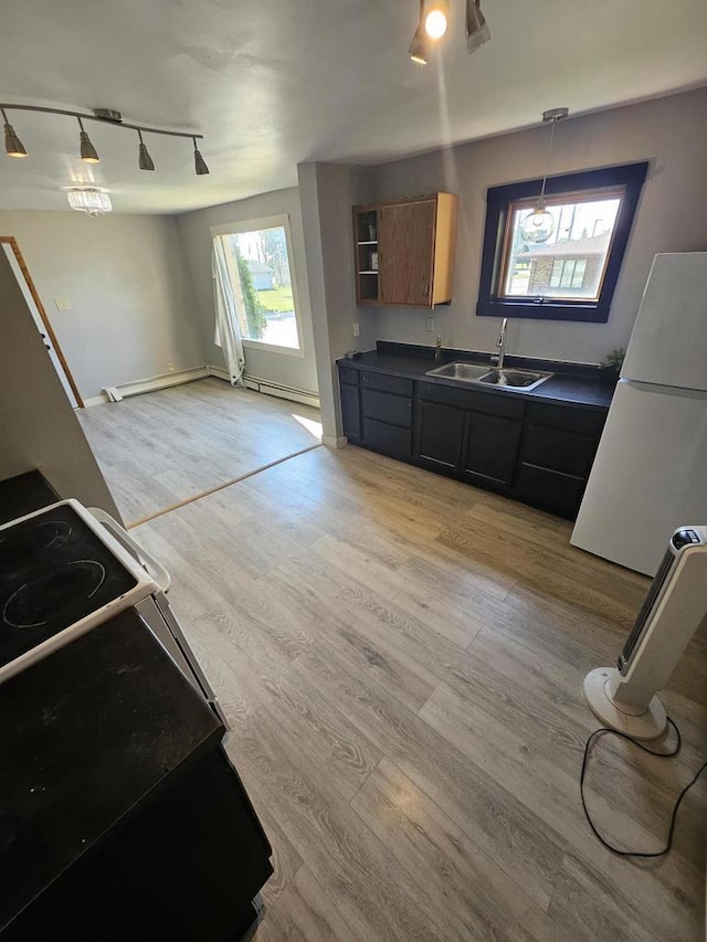 kitchen with light hardwood / wood-style flooring, pendant lighting, white fridge, sink, and electric range oven