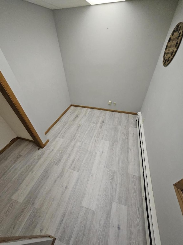 spare room featuring light hardwood / wood-style floors and a baseboard radiator