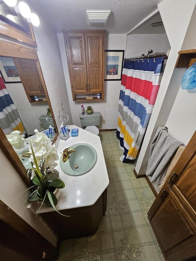 bathroom with toilet, vanity, and walk in shower