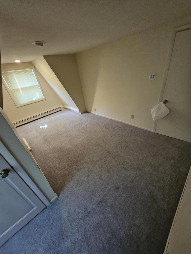 interior space featuring baseboard heating, lofted ceiling, carpet floors, and a textured ceiling