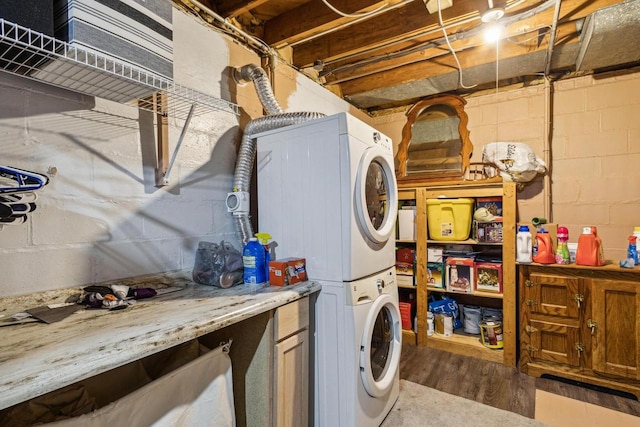 laundry area with hardwood / wood-style floors and stacked washer and dryer