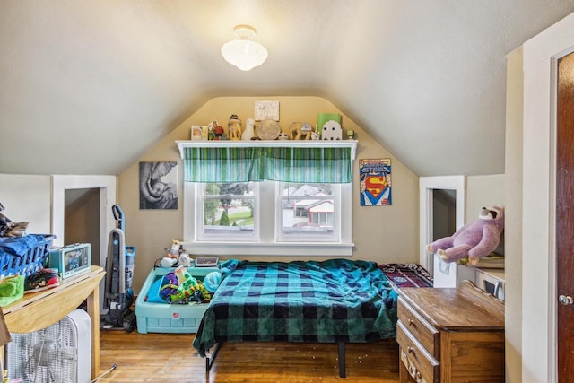 bedroom featuring hardwood / wood-style floors and lofted ceiling