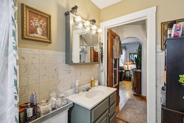 bathroom with hardwood / wood-style floors, tile walls, and vanity