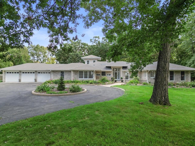 view of front of home with a front yard and a garage