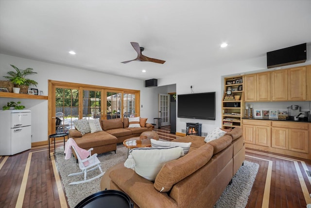 living room with dark hardwood / wood-style floors and ceiling fan