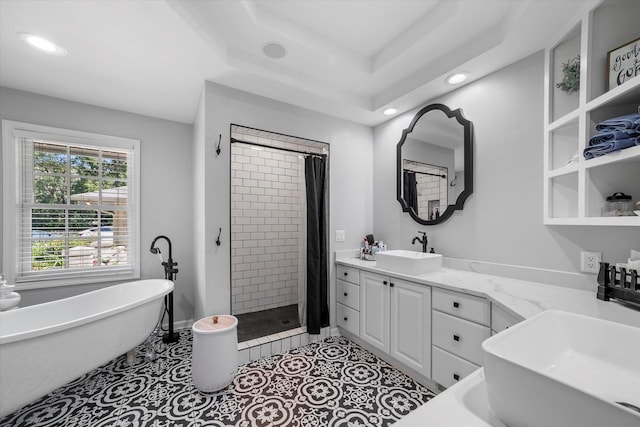 bathroom with tile patterned floors, vanity, shower with separate bathtub, and a raised ceiling