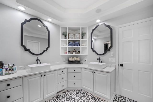 bathroom with tile patterned floors, a raised ceiling, and double vanity