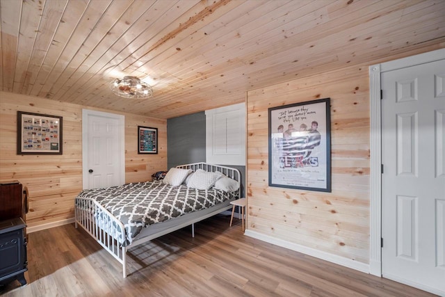 bedroom featuring wood-type flooring, wooden ceiling, and wooden walls