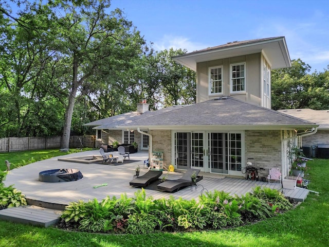 rear view of house with a fire pit and a deck