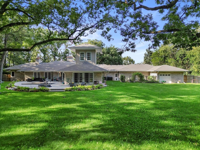 back of house with a garage and a lawn