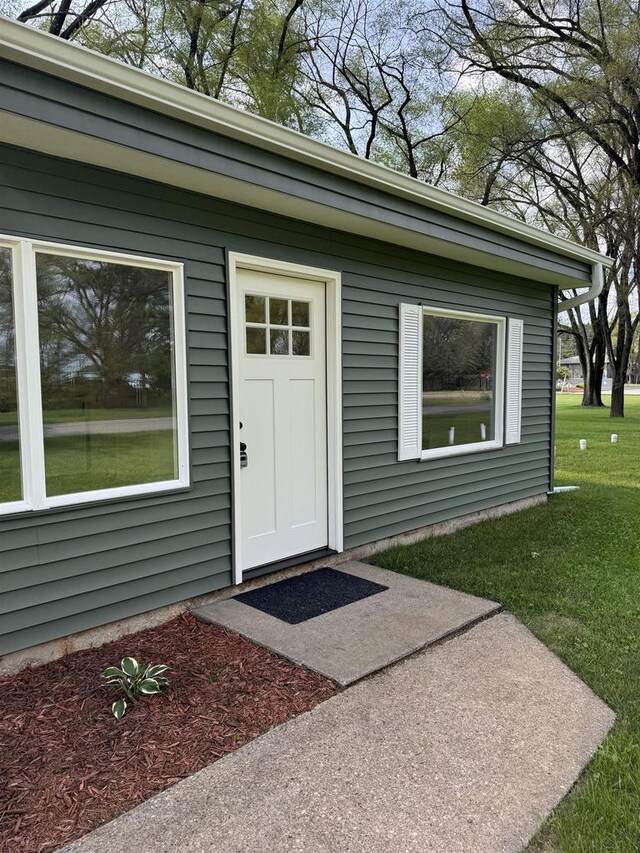 doorway to property with a lawn