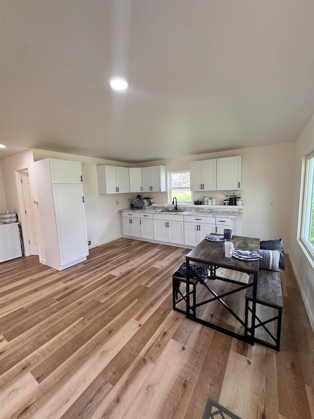 kitchen featuring sink, light hardwood / wood-style floors, and white cabinetry