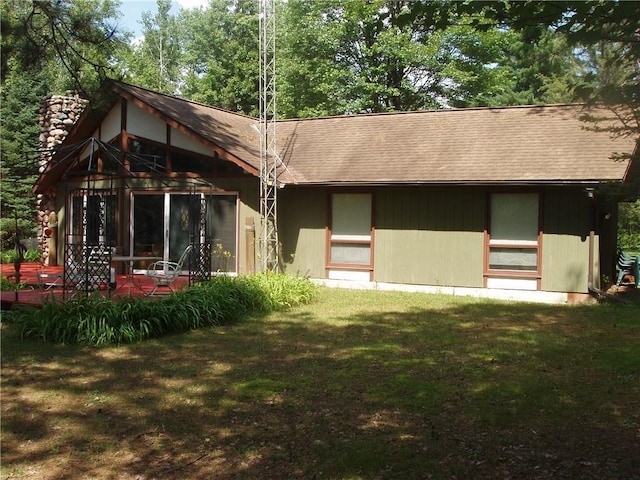 rear view of house featuring a yard, a chimney, and a patio area