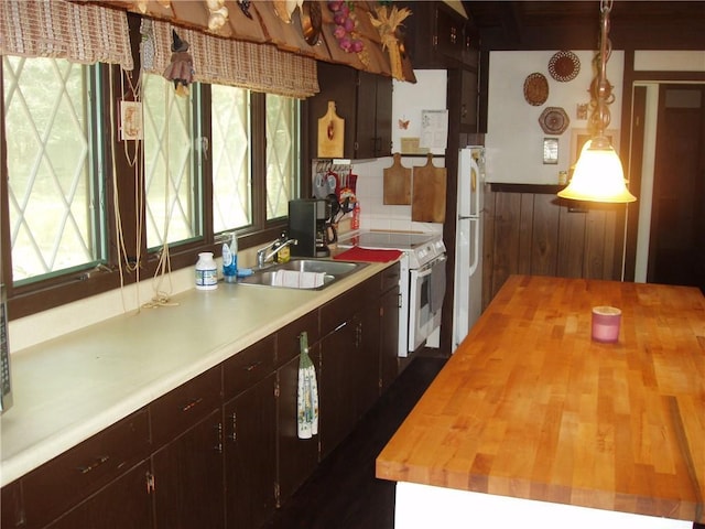 kitchen with white appliances, wooden counters, decorative backsplash, and a sink