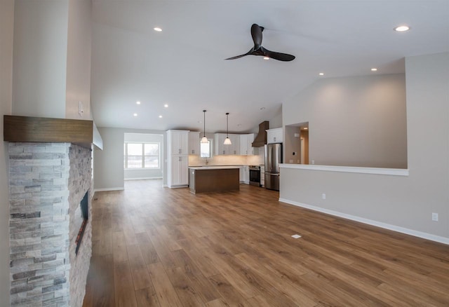 unfurnished living room featuring recessed lighting, ceiling fan, baseboards, and wood finished floors