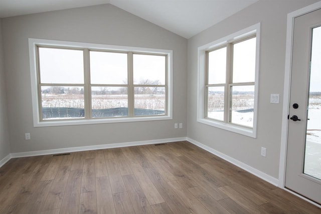 unfurnished room featuring vaulted ceiling, baseboards, visible vents, and light wood-style floors